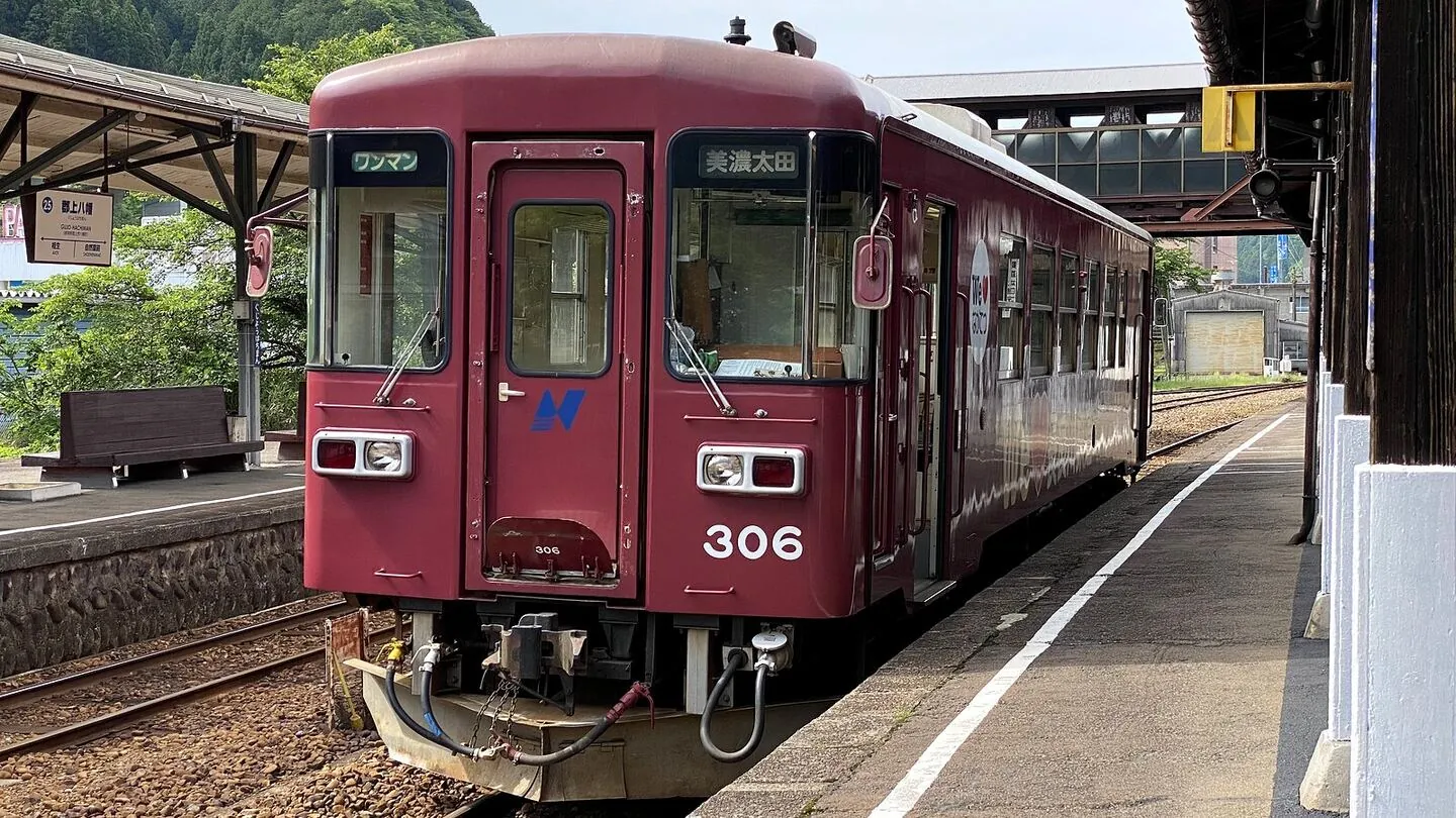 A Nagaragawa Railway train waiting at a local station platform on the line into Gujo Hachiman