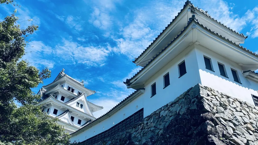 Gujo Hachiman Castle, a wooden reconstructed castle on a hill above the town, photographed on a clear day