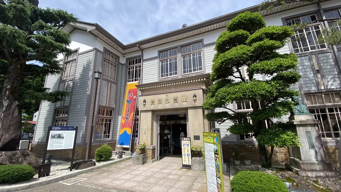 A traditional wooden shopfront in Gujo Hachiman's old craftsmen's quarter, with a potted bonsai tree by the entrance