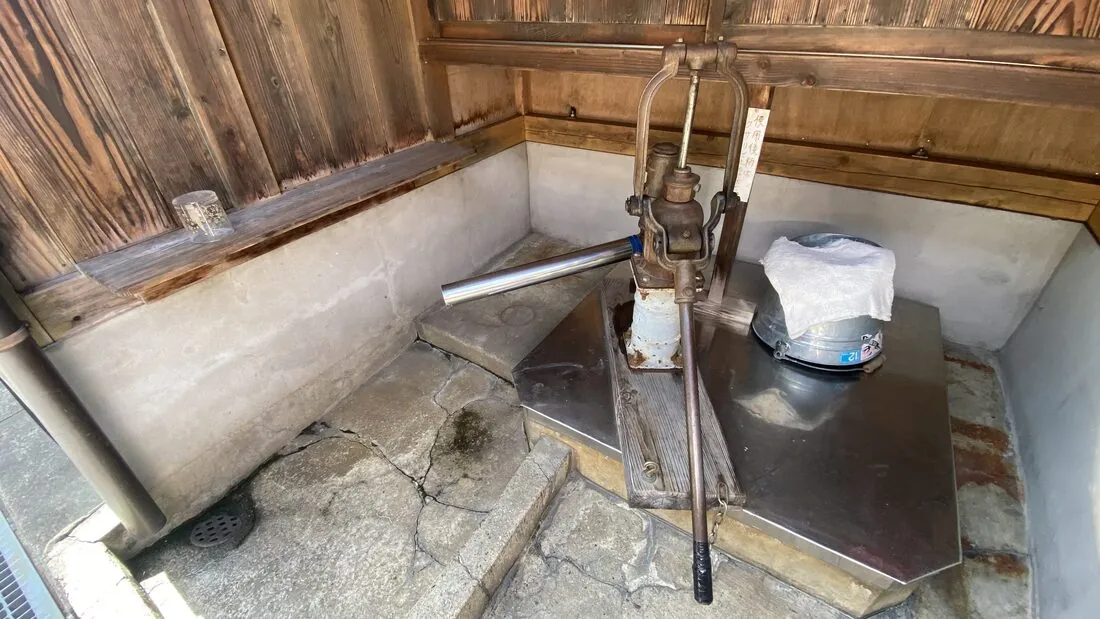 A close-up of a stone water trough (mizubune) in Gujo Hachiman, the kind locals use daily for washing vegetables and rice