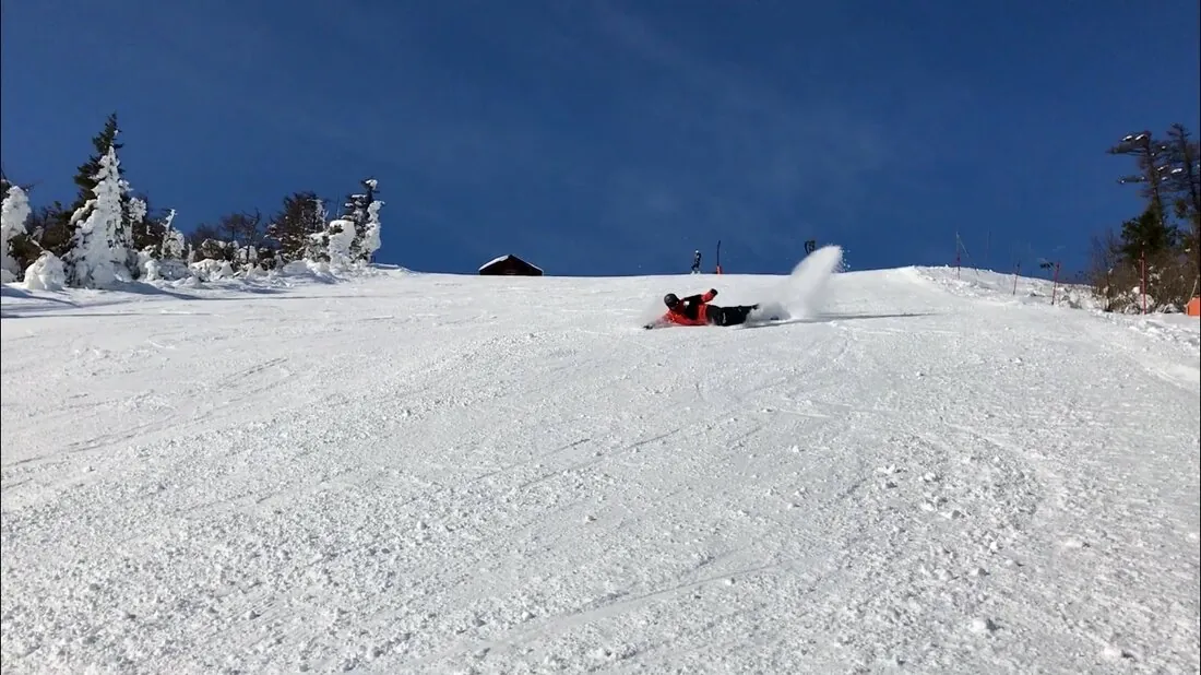 A snowboarder throwing up a spray of powder on a steep run through the trees at one of Gujo's ski resorts